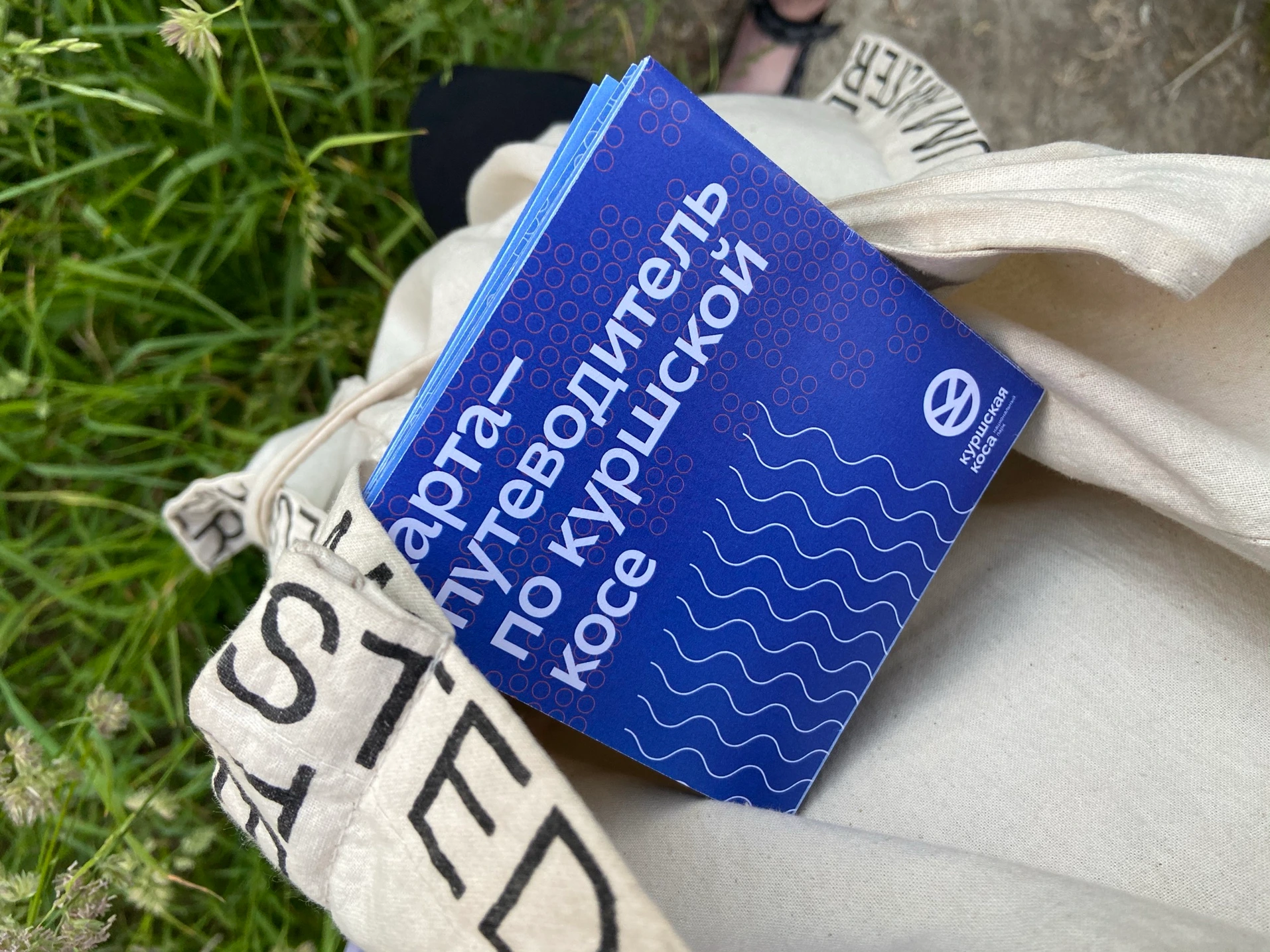 Booklet in a tote bag on grass
